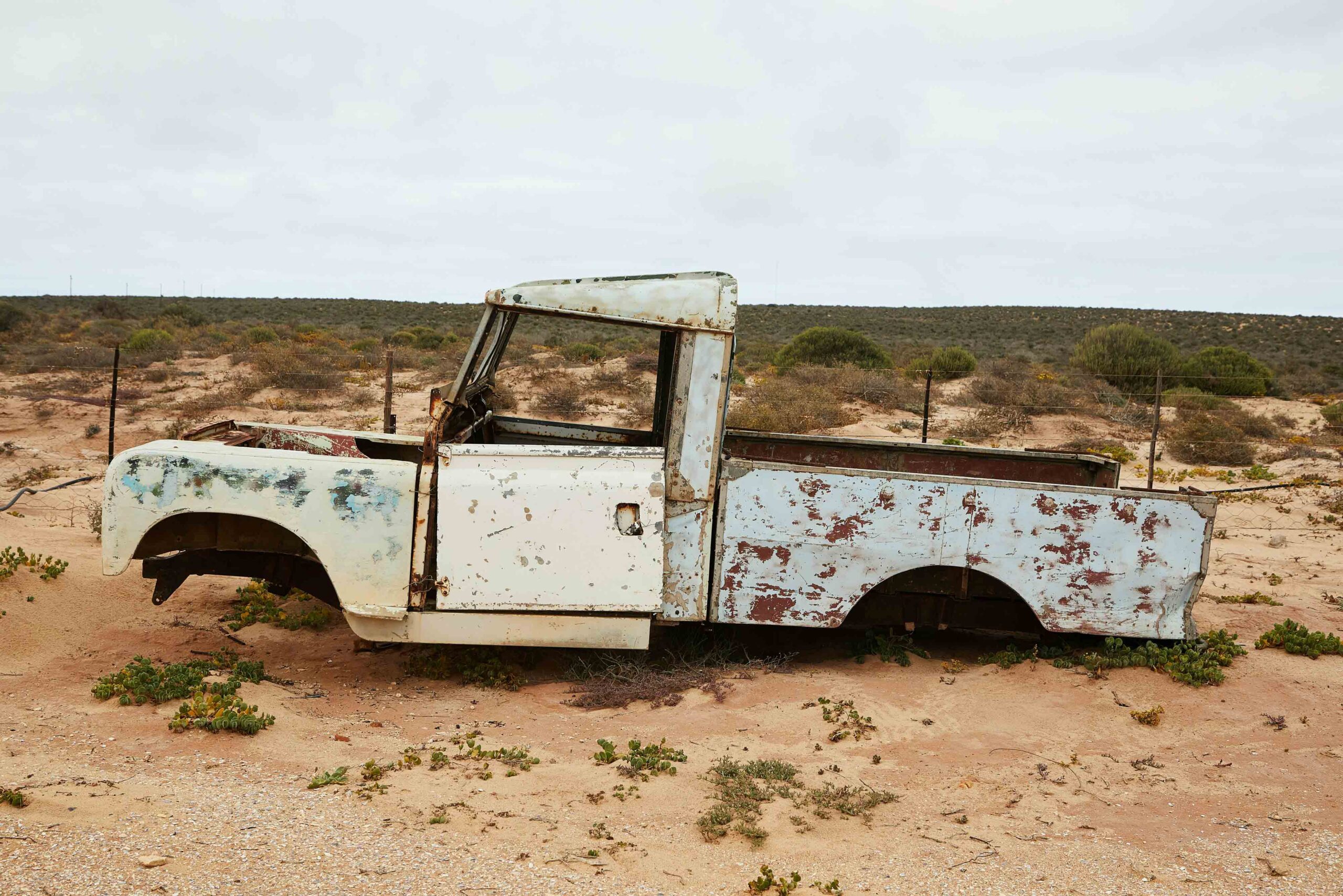 image of an old, rusty car in the desert