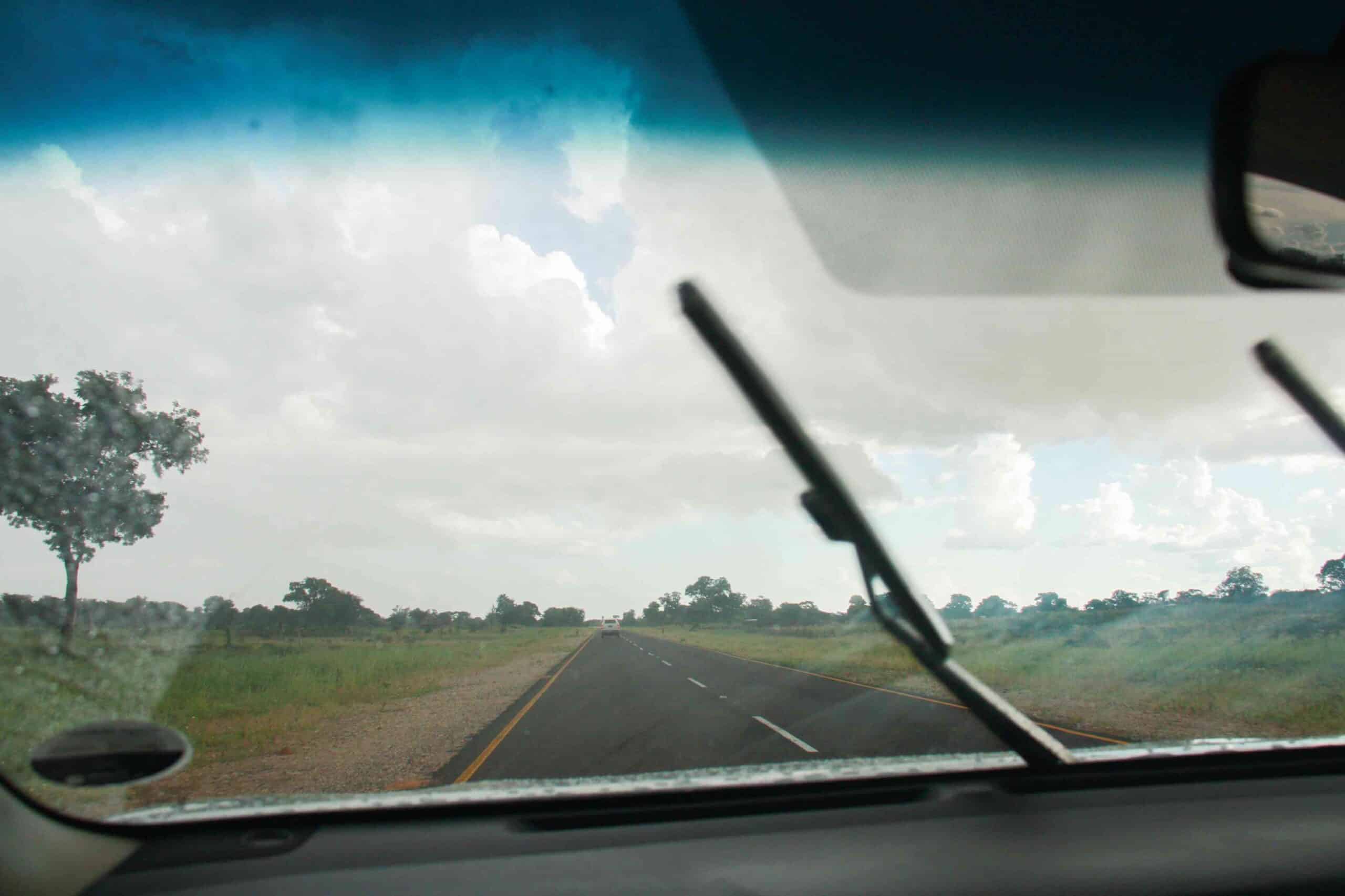 a road in namibia photographed through the windshield of a car