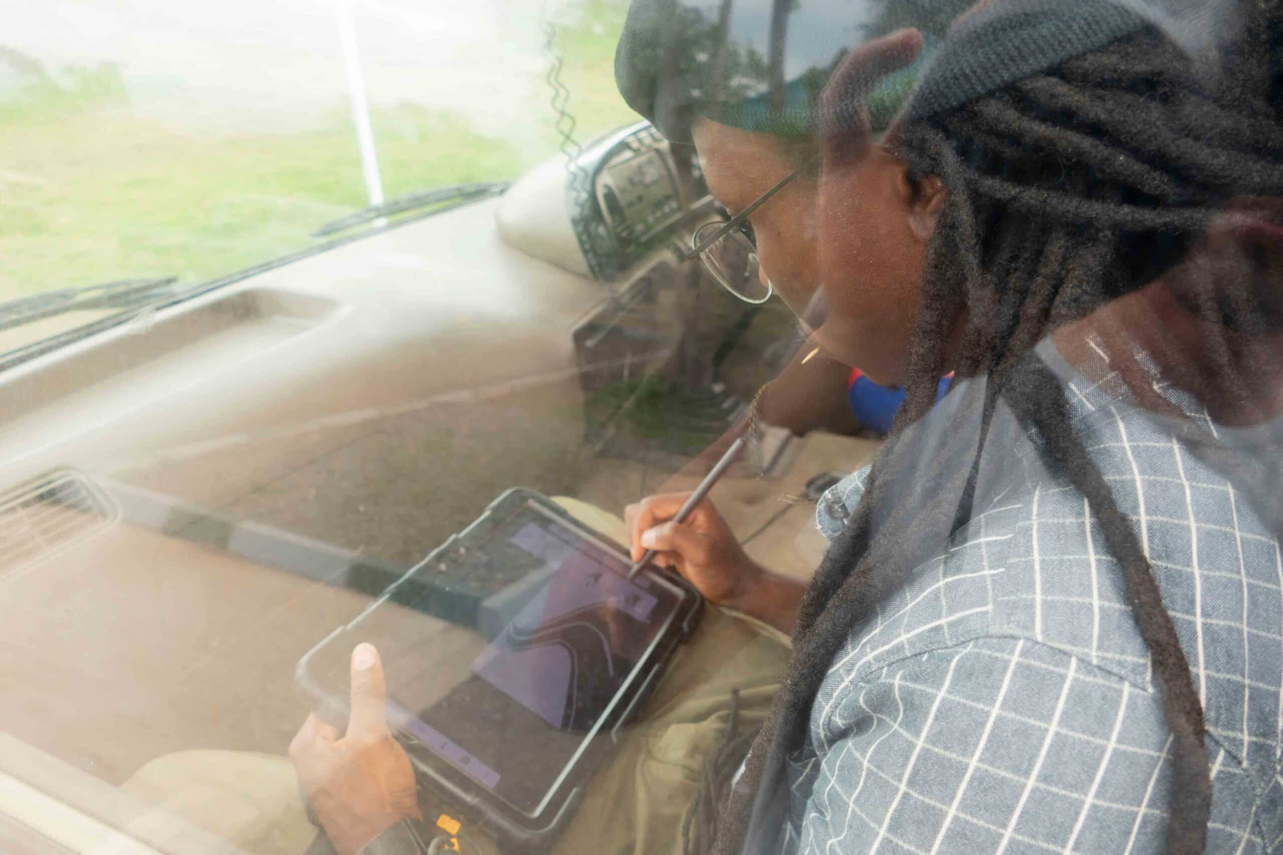 RESEARCHER DRAWING ON AN IPAD WHILE SITTING ON A BUS