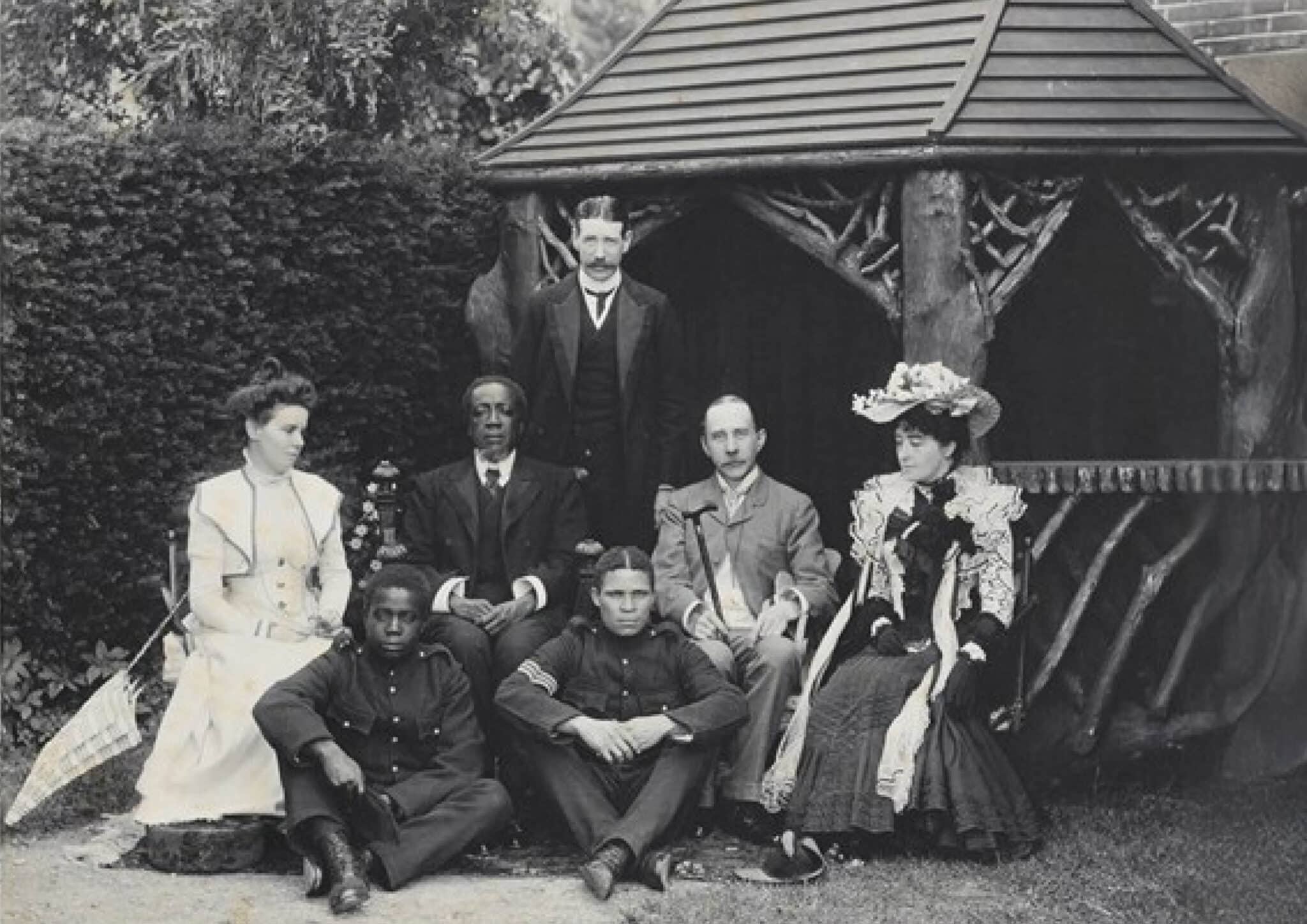 Group photograph taken at Langley Lodge, Oxford. From left to right: unknown; Sikota Ishee Kwandu (aide); Lewanika; Colin Harding (standing); Amba (aide); Philip Lyttelton Gell; Edith Mary Gell. Source: Matlock, Derbyshire Record Office,