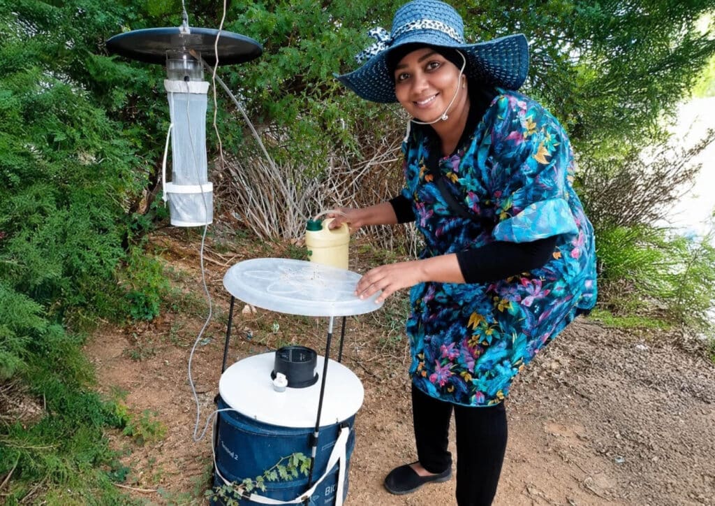 researcher in the field operating a mosquito trap